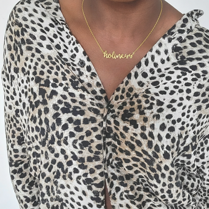 Gold Holiness Christian necklace with script word pendant worn around the neck
