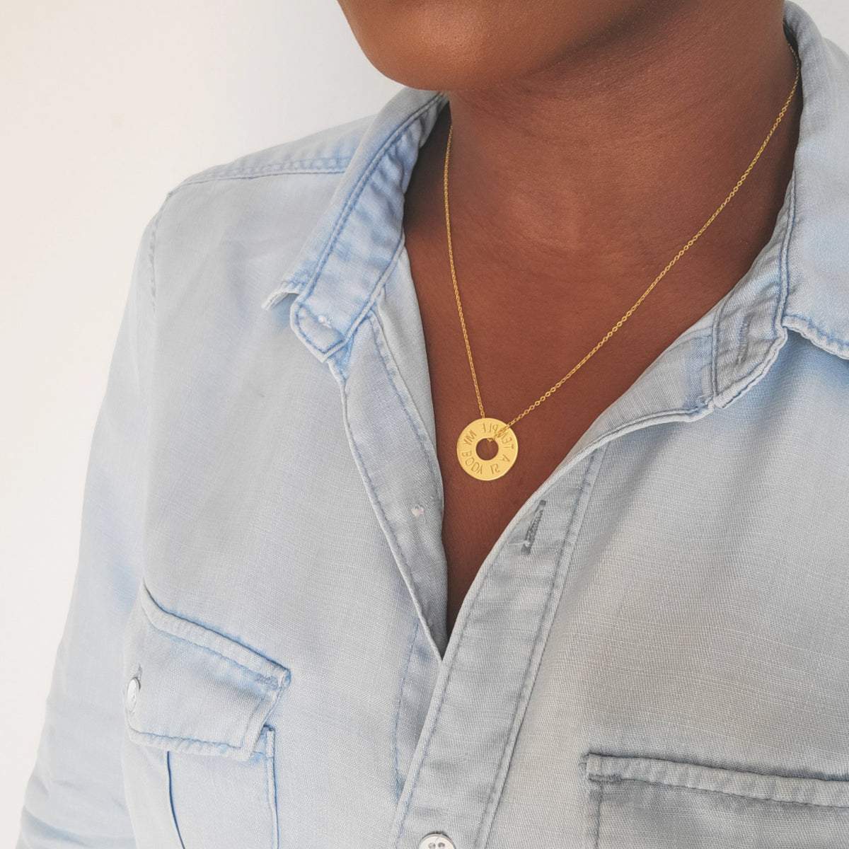 Gold My Body Is A Temple Christian necklace with engraved round pendant worn around the neck